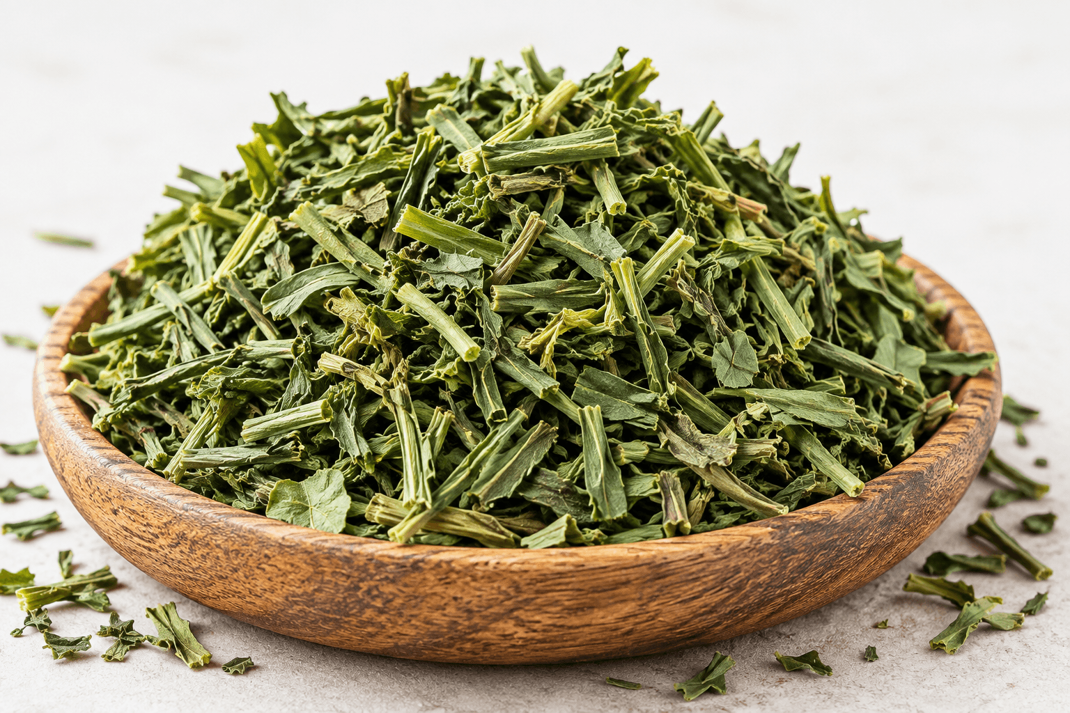 Dried chopped fenugreek leaves and stems in a wooden bowl